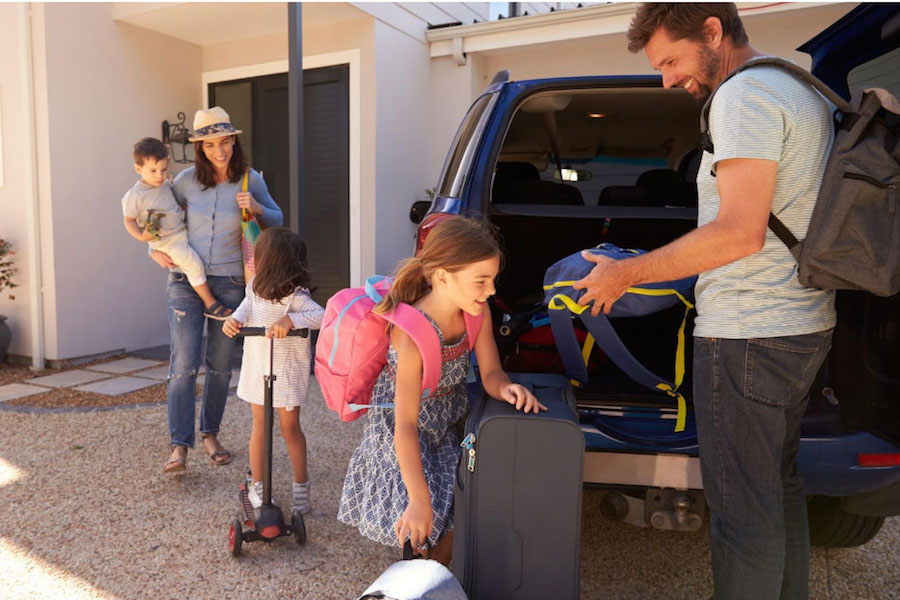 Photo of family unloading luggage from car