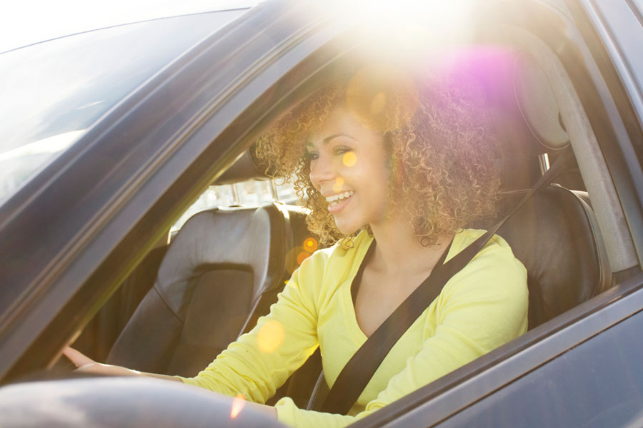Photo of lady in a yellow shirt drivinga car