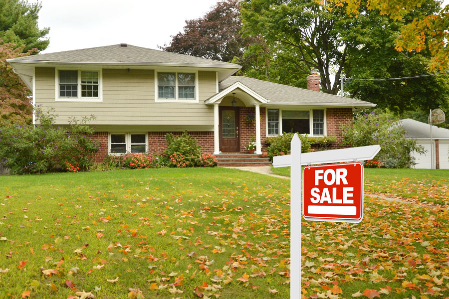 Photo of for sale sign in yard of two story home