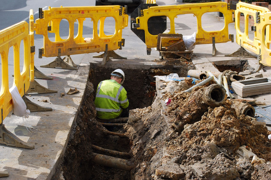 Photo of construction worker digging water lines