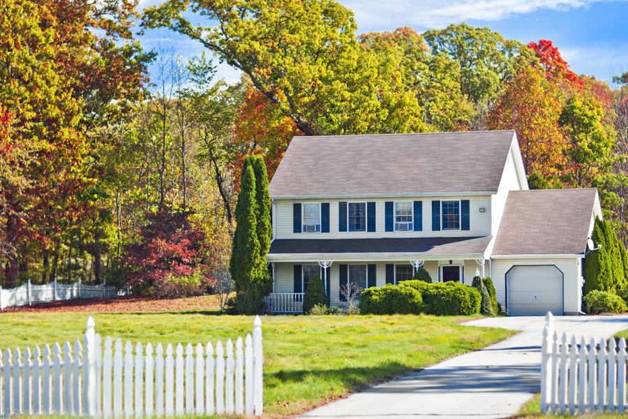 Photo of two story home with white picket fence