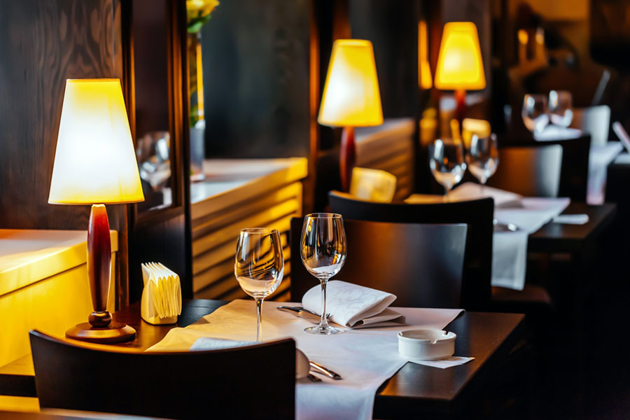 Photo of table setting with dim lighting and wine glasses