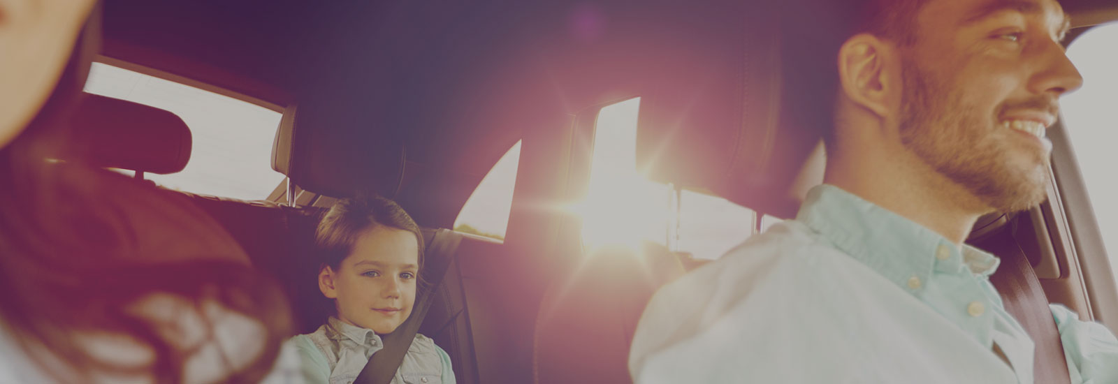 Photo of a family with a child riding inside a car