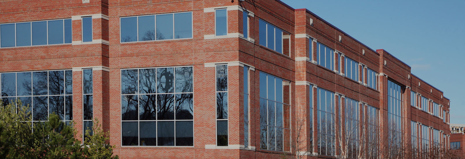 Photo of the exterior of a brick building with many windows