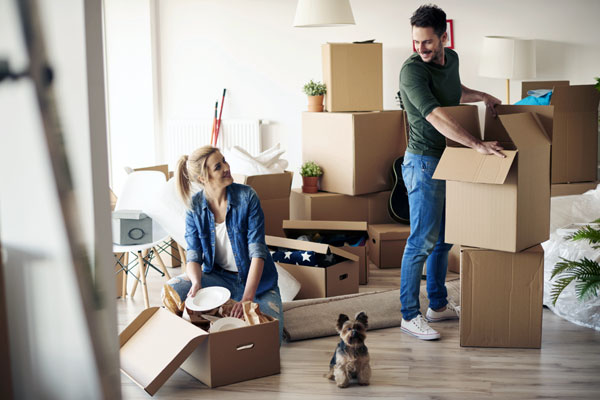 A young couple lifting boxes while moving to a new home or apartment