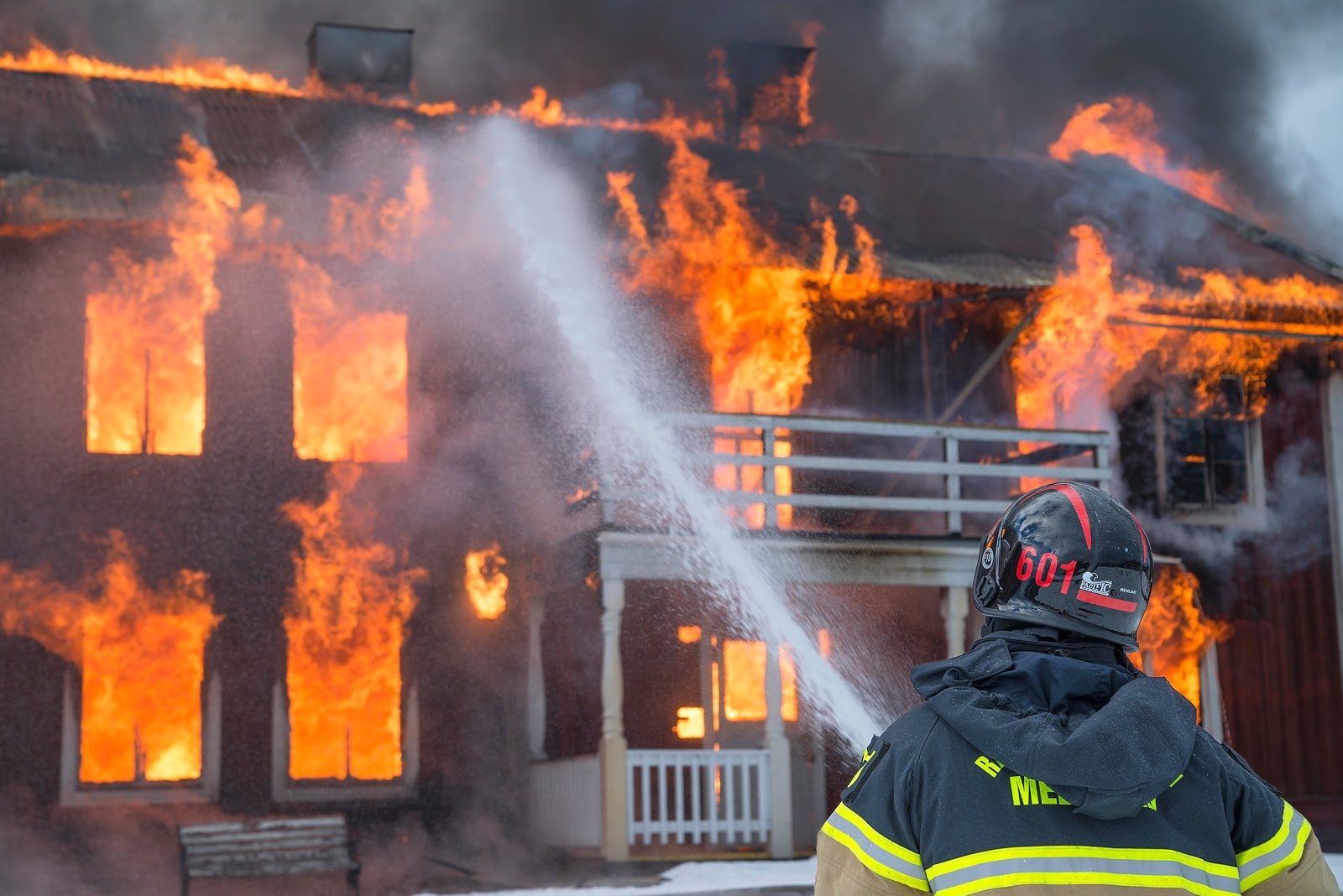 firefighter putting out burning home