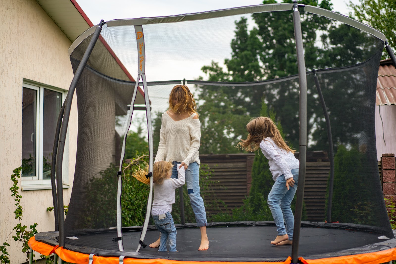 Photo of a mother with two daughters on a trampoline